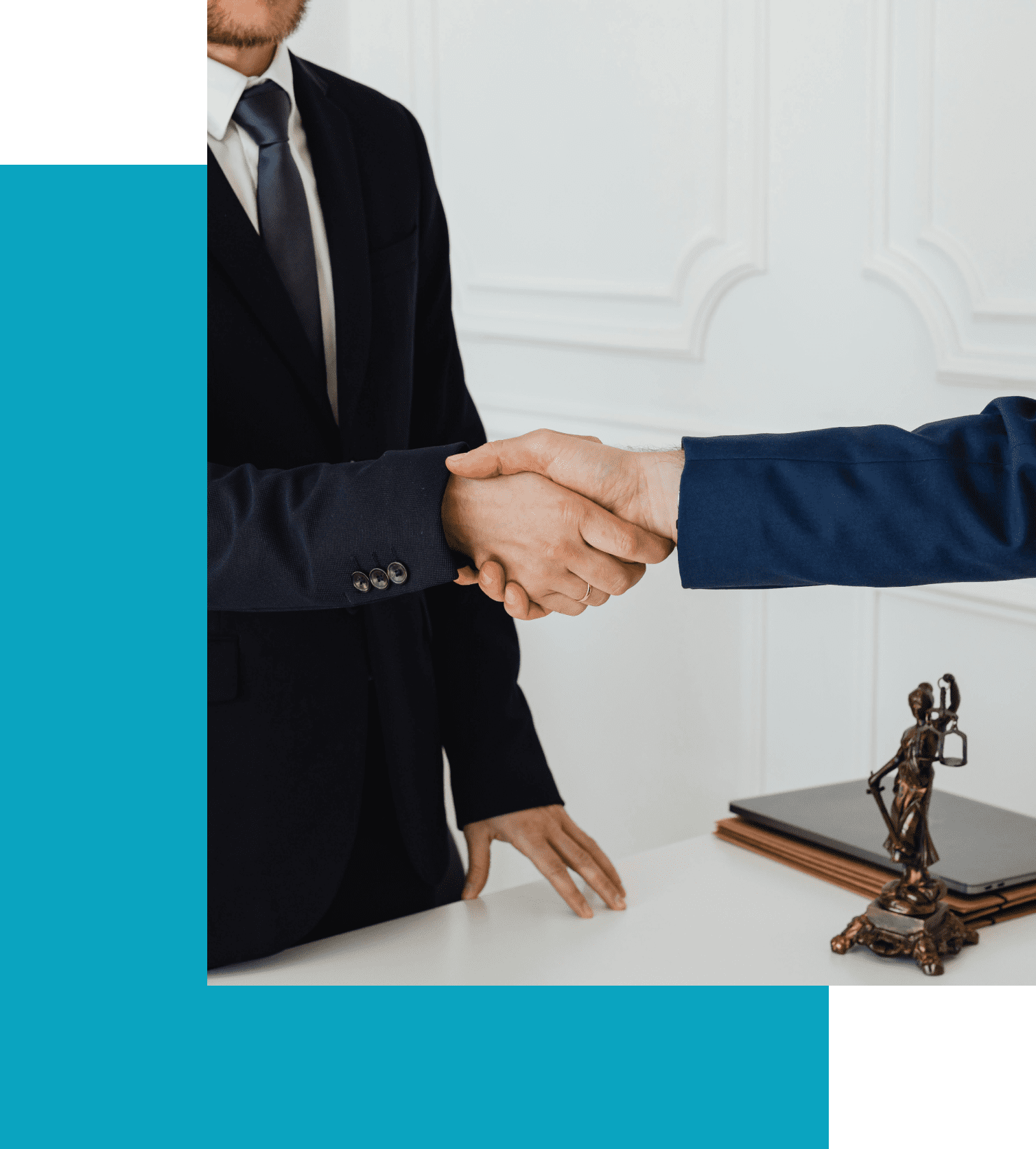 Two men in formal attire shake hands over a desk. A small statue of Lady Justice and some documents are partially visible on the desk.